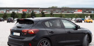 Czarny hatchback Citroëna zaparkowany na dużym, otwartym parkingu