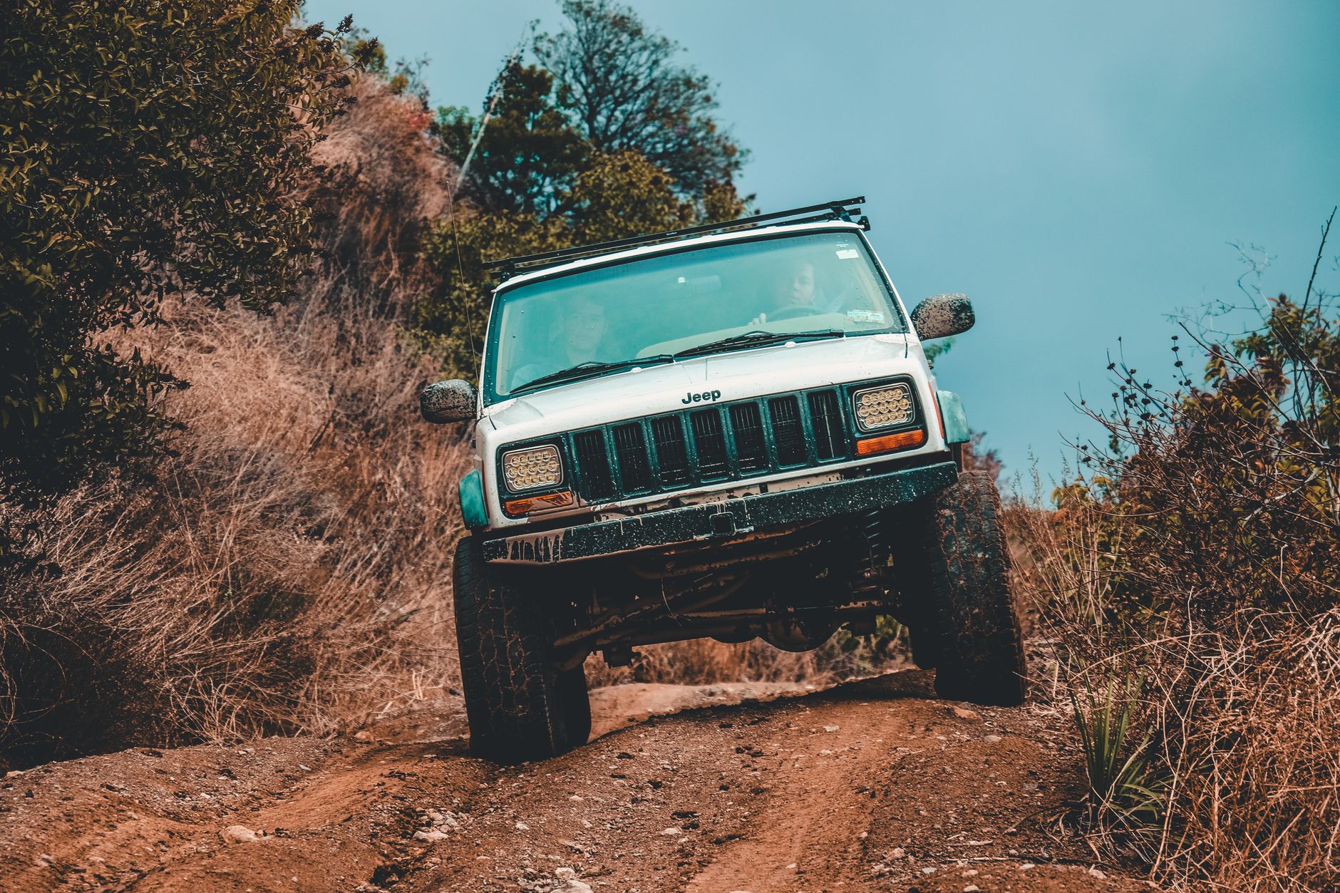 Jeep 4x4 jedzie po błotnistym, leśnym szlaku offroadowym