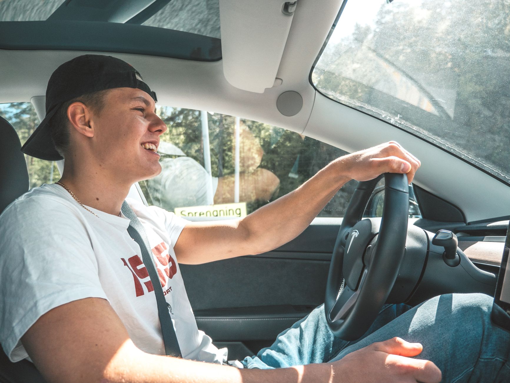Młody mężczyzna zadowolony prowadzi nowoczesne auto podczas jazdy