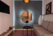 Jak fotografować mieszkanie do ogłoszenia sprzedaży: praktyczny poradnik krok po kroku Nowoczesny salon z sofą, telewizorem i okrągłym lustrem na ścianie