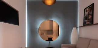 Nowoczesny salon z sofą, telewizorem i okrągłym lustrem na ścianie